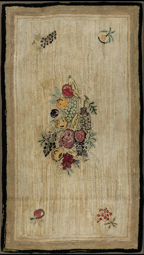 Tan textured rug featuring a dark border and a large central bouquet of brightly colored fruit and flowers.