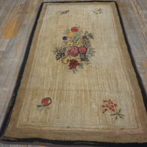 Beige runner rug with a colorful fruit and floral pattern on distressed gray wooden flooring.