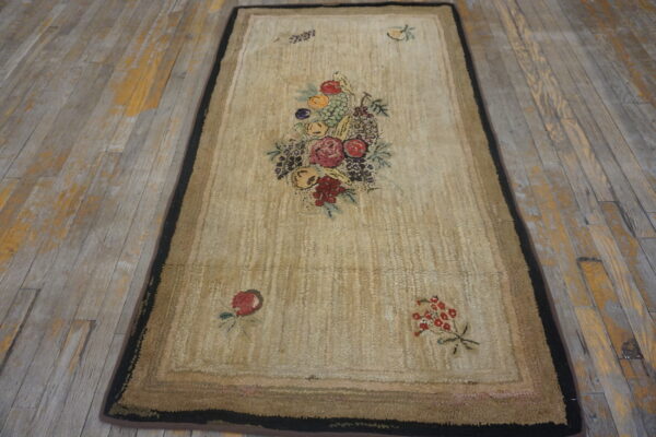 Beige runner rug with a colorful fruit and floral pattern on distressed gray wooden flooring.