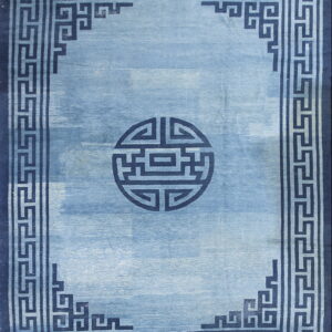 Monochromatic blue rug with a light blue field, a dark geometric border, and a circular central motif.