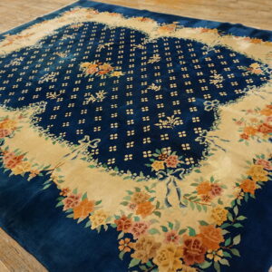 High-pile blue rug featuring a contrasting beige field densely patterned with colorful floral bouquets on wood planks.