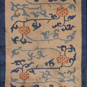 A beige rug with an indigo border and a scrolling pattern of rust florals and blue clouds.