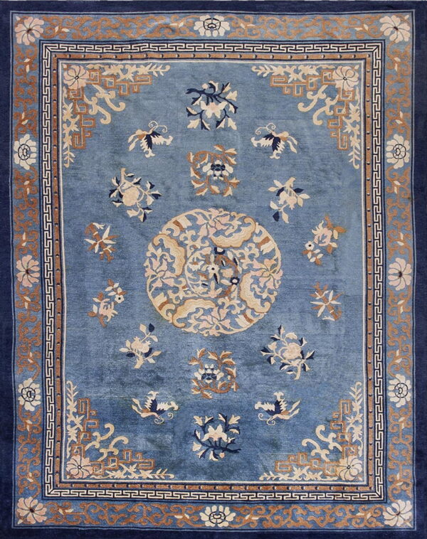 Blue traditional rug with a central medallion and scattered florals in tan, cream, and dark blue.