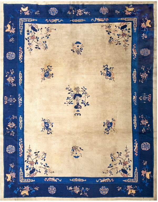 Beige rug with a dark blue border, featuring scattered floral and vase motifs in the center field.