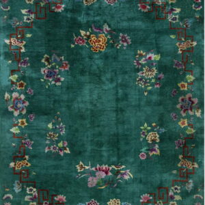Teal rug with colorful scattered flowers and a thin, rust-colored geometric border frame.