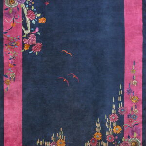 Striking navy and fuchsia rug featuring brightly colored stylized blossoms and two small orange birds.