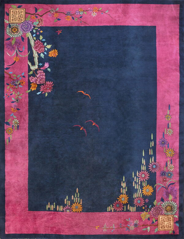 Striking navy and fuchsia rug featuring brightly colored stylized blossoms and two small orange birds.