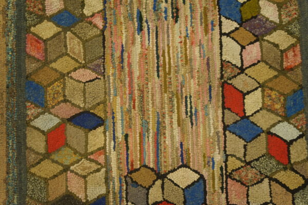 Textured rug displaying multicolored cubes flanking a center panel of chunky vertical fabric strips.