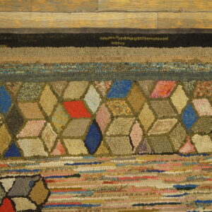 Highly textured rug with colorful geometric and striped patterns on a light brown wood floor.