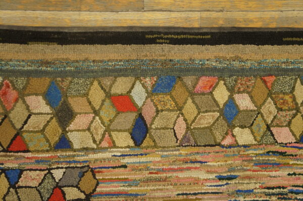 Highly textured rug with colorful geometric and striped patterns on a light brown wood floor.