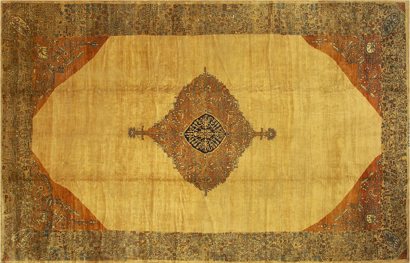 Detailed view of an antique central rug featuring deep madder reds and navy blue medallions - by rugs on net