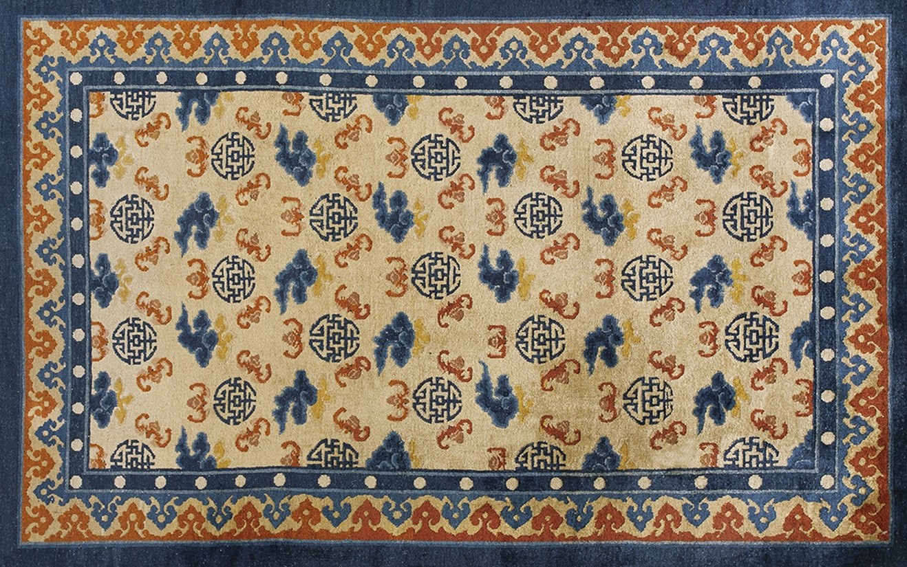 Close-up view of an antique chinese rug showing the muted gold field and floral border - by rugs on net