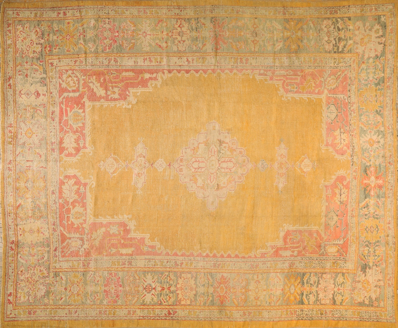 Antique oushak pile rug displaying a large central floral medallion and detailed border - by rugs on net