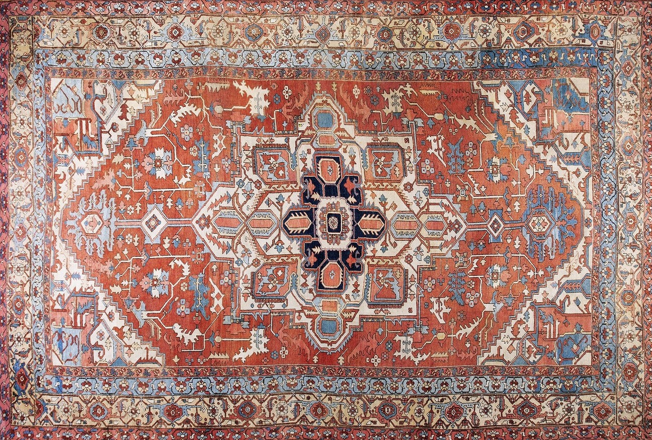 Wide view of a grand antique serapi rug with central medallion design on hardwood floor - by rugs on net