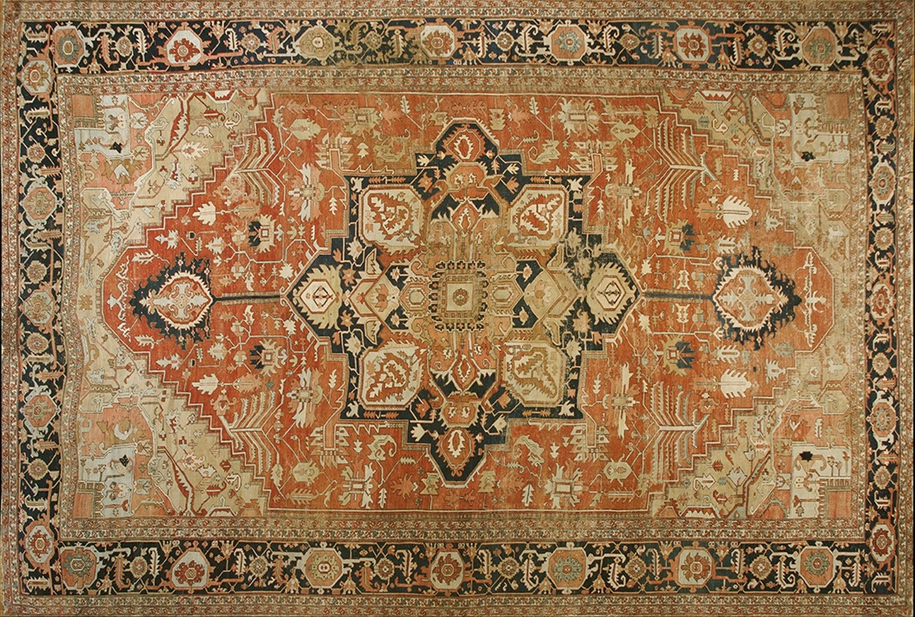 Oversized antique serapi wool rug featuring an ornate geometric medallion pattern and a rich coral main field - by rugs on net