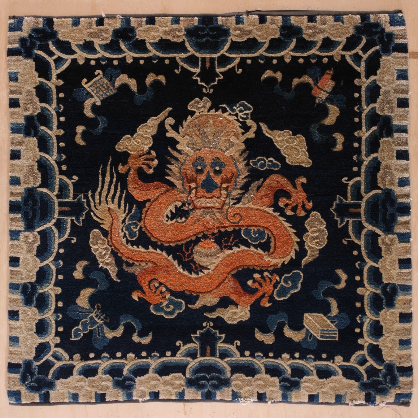 Close-up view of an antique wool scatter rug with detailed blue and terracotta floral motifs - by rugs on net