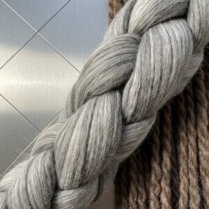 Extreme close-up of thick, braided gray yarn resting against thick brown yarn texture – by rugs on net