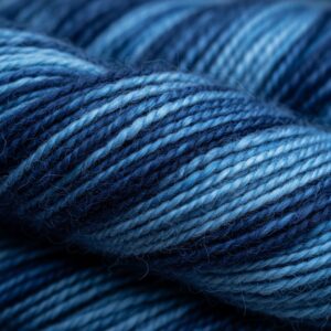 Close-up of tightly spun yarn showing variegated shades of deep navy to light sky blue fibers – by rugs on net
