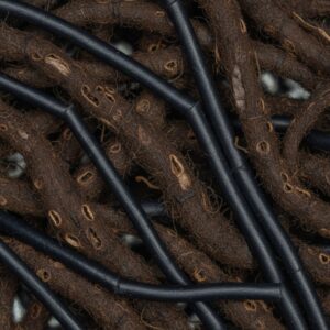 Close-up of dark brown, textured, fibrous strands interwoven with smooth, thick black cylindrical cables – by rugs on net