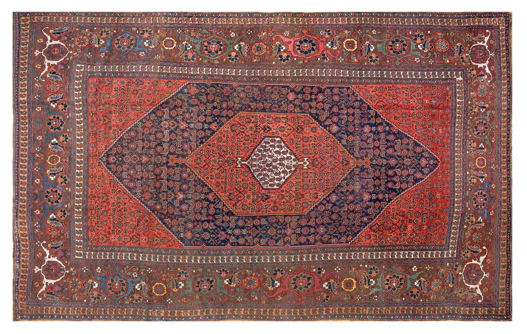 An antique, large-sized persian bidjar rug featuring a central field with nested diamonds in red and dark blue, surrounded by elaborate floral borders in earth tones. By rugs on net