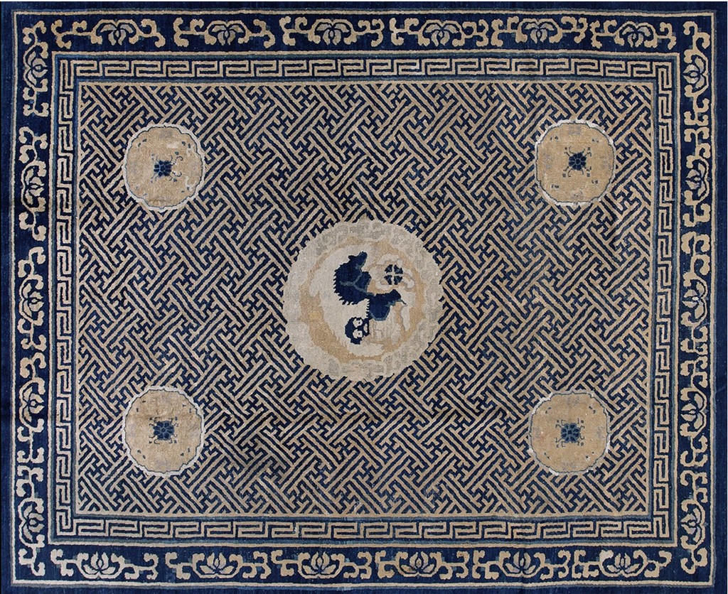 An antique rectangular rug with a dark indigo blue field dominated by a dense, interlocking tan geometric lattice pattern. It features one large central circular medallion and three smaller corner medallions in muted beige and blue, framed by ornate blue and tan borders. By rugs on net