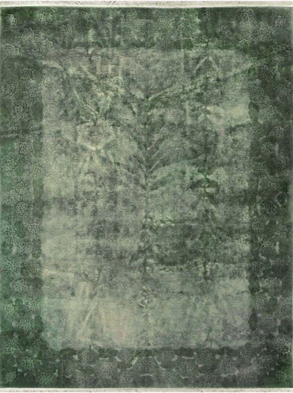 Distressed green rug with a faded floral border surrounding a lighter central field of subtle pattern.