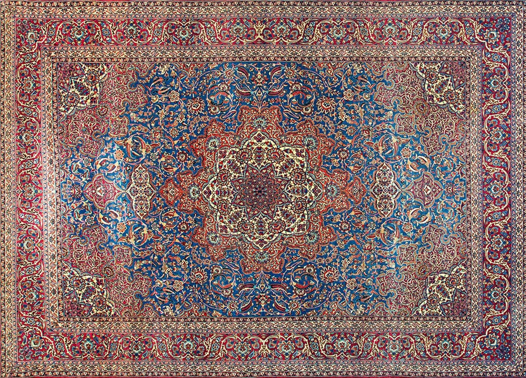 An overhead view of an antique persian rug from isfahan featuring an allover geometric pattern dominated by deep blue and rich red colors surrounding a large central medallion, by rugs on net.