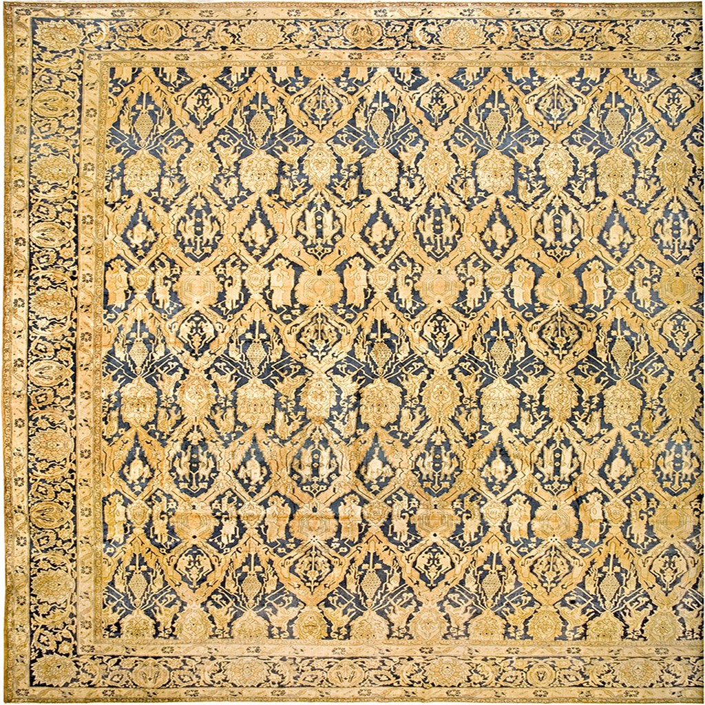 A large antique indian amritsar rug with an all-over diamond lattice design in golden yellow on a dark indigo blue field, enclosed by a detailed floral border, by rugs on net.