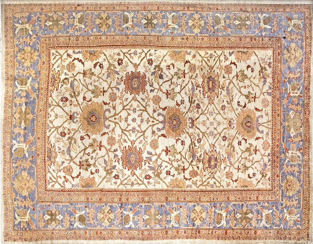 A rectangular antique sultanabad zeigler shah abbas patterned area rug featuring an ivory field with flowing floral vines in rust and taupe, framed by a wide periwinkle blue border by rugs on net.