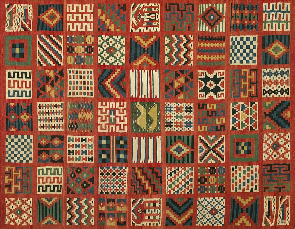 A detailed, flat-woven antique kilim rug from gafsa, tunisia, featuring a grid layout of numerous small, colorful geometric and abstract motifs set against a vibrant red background, by rugs on net.