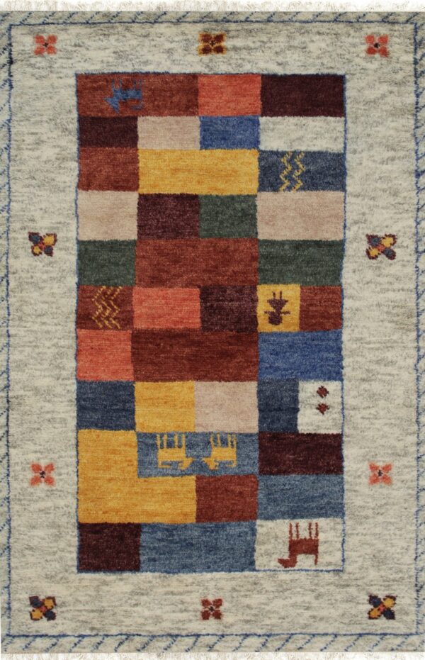 Beige rug with stylized figures and a multi-colored geometric border, folded on wood plank flooring.