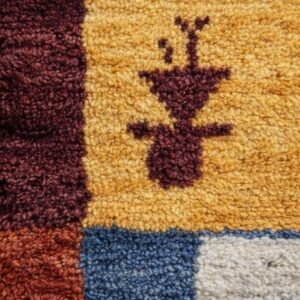 Textured beige rug with stylized animals and figures, strong red and black geometric borders, and fringe.