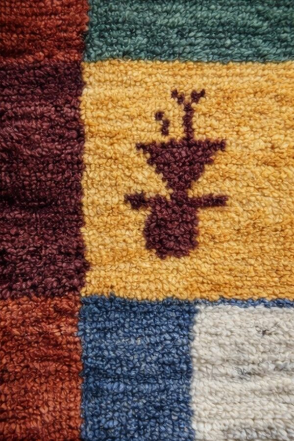 Textured beige rug with stylized animals and figures, strong red and black geometric borders, and fringe.