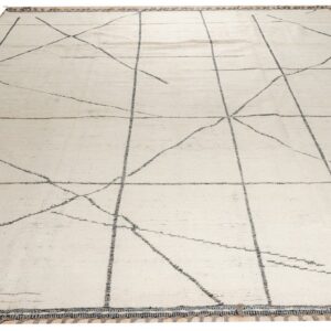 Large cream rug with light gray geometric intersecting lines and decorative tassels on a wood floor.