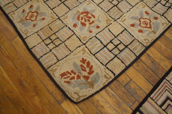 Close-up of a hooked rug with geometric and floral motifs in beige, rust, and blue, resting on wood floors, by rugs on net
