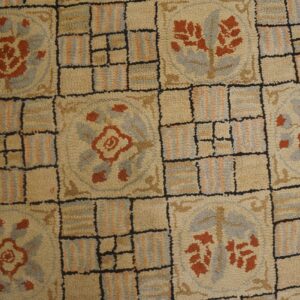 Close-up of a beige hooked rug with repeating floral medallions and grid pattern, by Rugs On Net