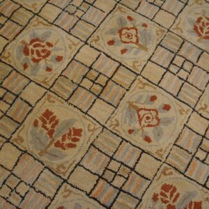 Close-up of a hooked rug with a geometric pattern featuring terracotta roses in medallions by Rugs On Net. by Rugs On Net