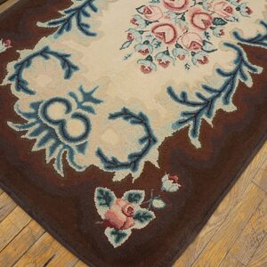 Close-up of a brown floral rug with pink roses and blue accents on a light center, by Rugs On Net