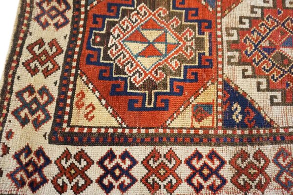 Close-up of a vibrant geometric pattern on an antique rug by rugs on net. By rugs on net