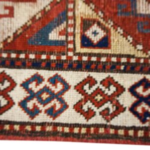 Close-up of geometric border patterns on an antique rug by Rugs On Net