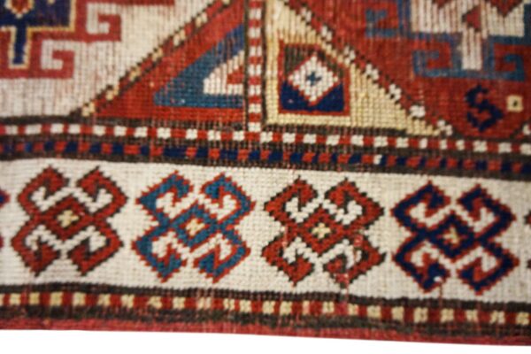 Close-up of geometric border patterns on an antique rug by rugs on net