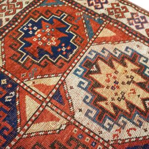 Close-up of geometric motifs on a richly colored rug by Rugs On Net