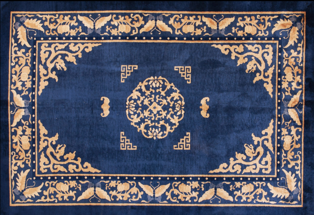 Deep blue rug with a gold central floral medallion, ornate corner spandrels, and a butterfly motif border by rugs on net