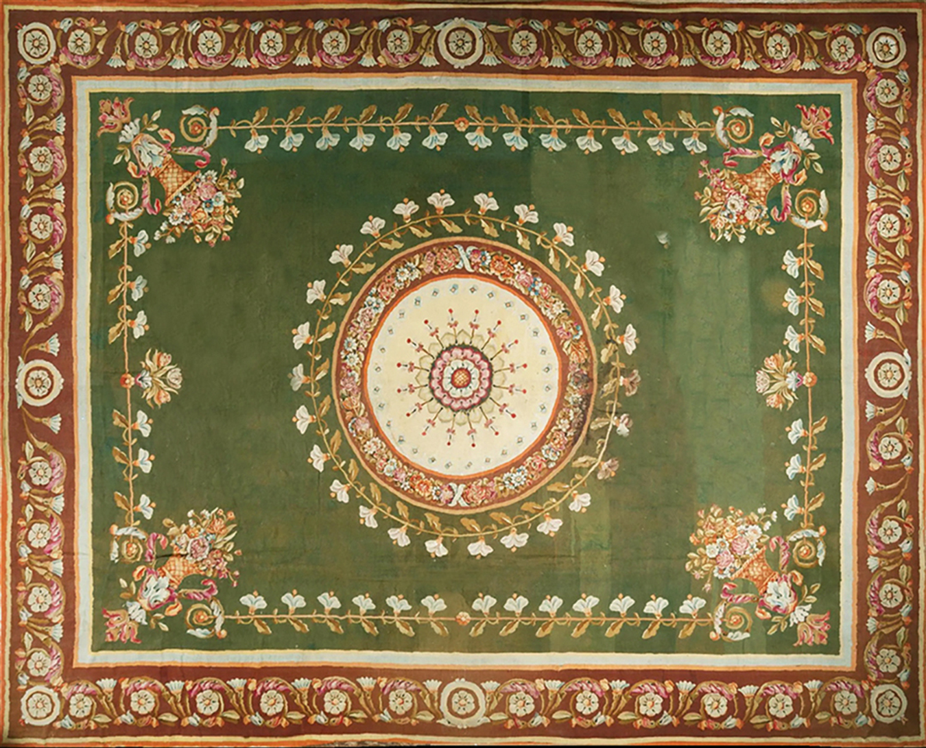 Traditional green rug with a central floral medallion, corner bouquets, and a deep red ornate border by rugs on net