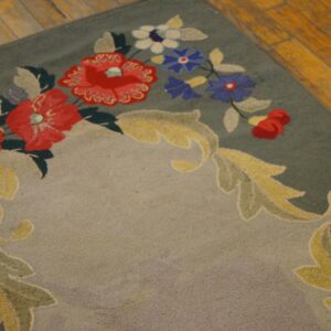 Close-up of a green rug with red, white, and blue floral patterns and yellow scrollwork, by Rugs On Net