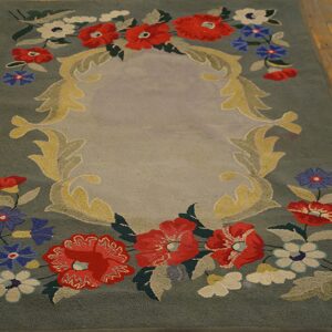 A hooked rug featuring a central medallion framed by red, blue, and white flowers on a sage green field, by Rugs On Net. by Rugs On Net