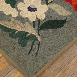 Close-up of a floral hooked rug corner with cream flowers on a gray-green field by Rugs On Net