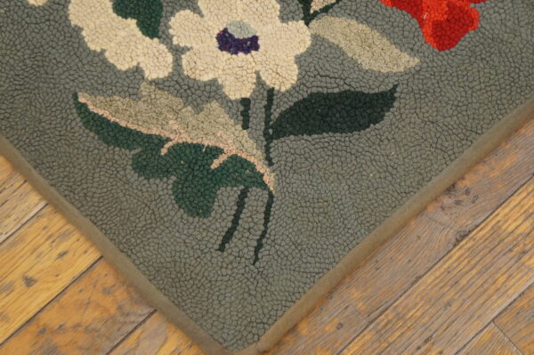 Close-up of a floral hooked rug corner with cream flowers on a gray-green field by rugs on net