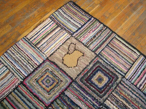 Close-up of a colorful, scrappy rag rug with geometric patterns and a central tan shape, by rugs on net
