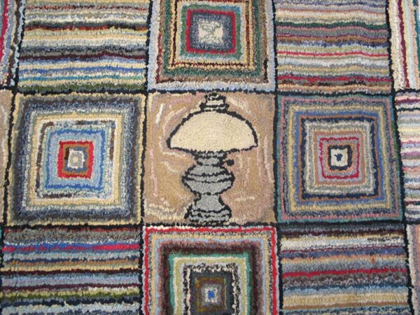 Close-up of a colorful hooked rug featuring squares and a central lamp motif, by rugs on net